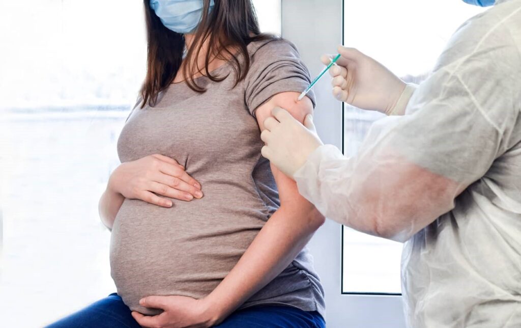 Mulher grávida tomando vacina
